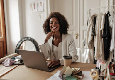 Imagem de capa de empreendedora sorrindo, em seu espaço de trabalho home office