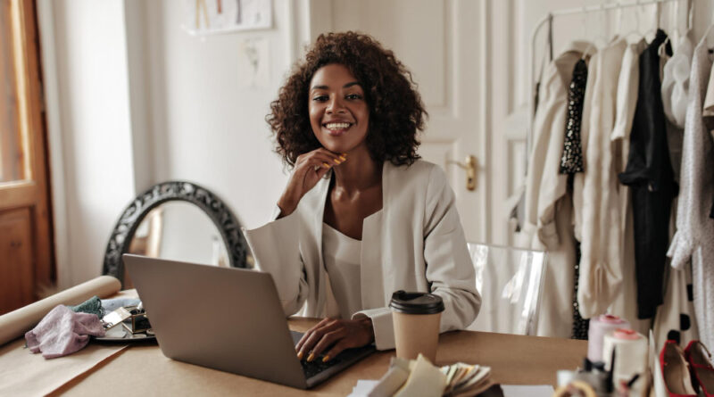 Imagem de capa de empreendedora sorrindo, em seu espaço de trabalho home office
